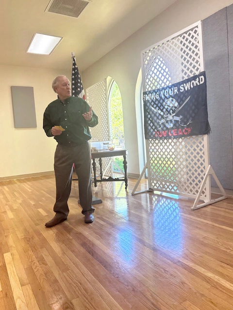 Alan standing to present a program on Squib-Kick it to a Fat Guy