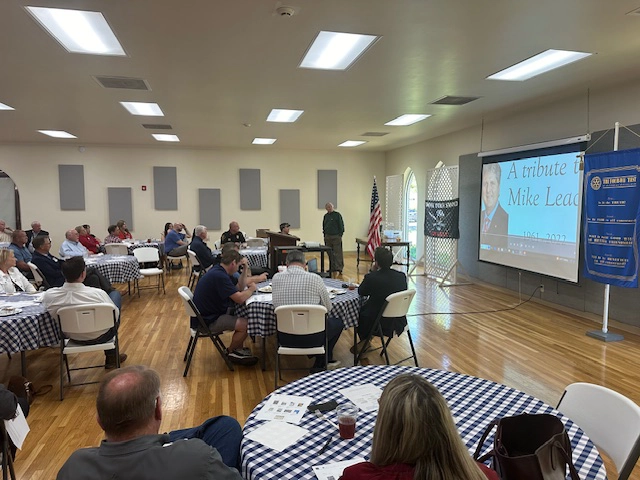 tables in a civic center watching Alan Burton present a program on Squib-Kick it to a Fat Guy